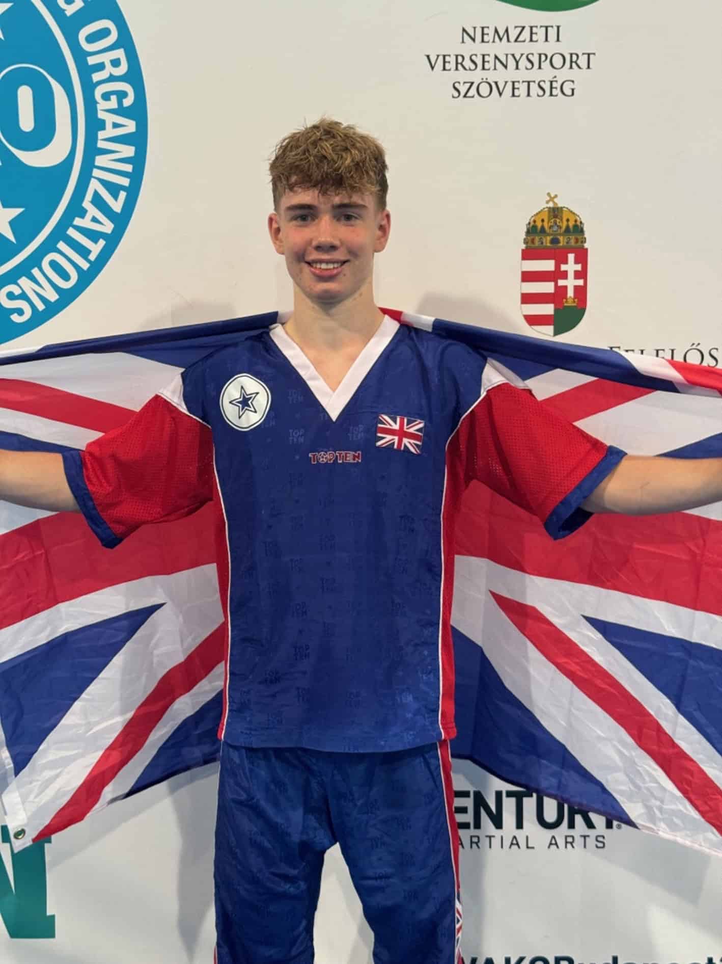 Cheadle Hulme Sixth Form and Elite pathway student Rory holds the union jack flag around him as the Junior Men’s Kickboxing World Champion.